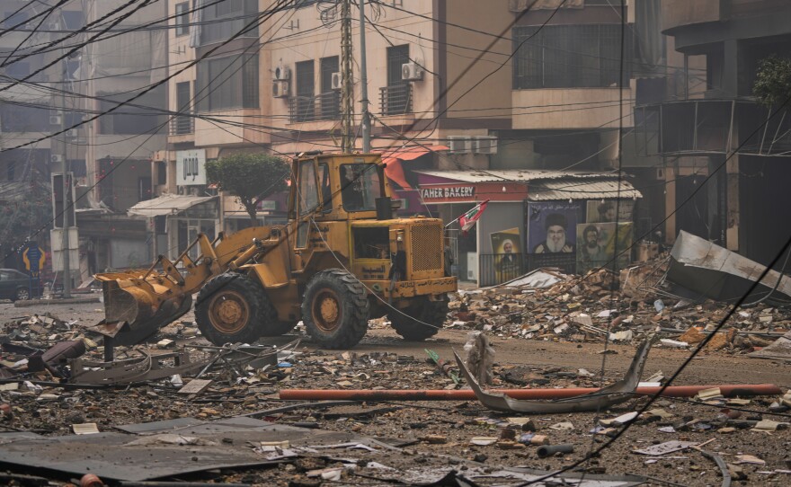 A bulldozer clears debris from the rubble of buildings destroyed in an Israeli airstrike in Dahiyeh, Beirut's southern suburbs, Lebanon, Sunday, March 15, 2026.