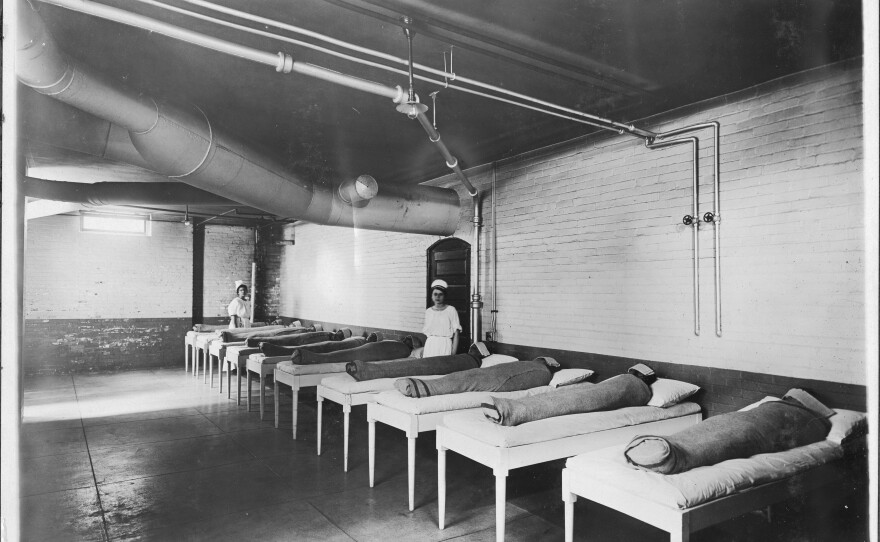 In one hydrotherapy practice, attendants wrap patients in wet sheets and wait for several hours. The photo above was taken circa 1900.