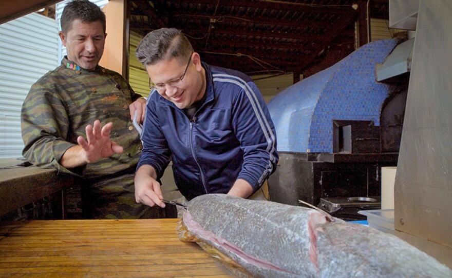 Host Jorge Meraz (right) carves up a fish with chef Miguel Angel Guerrero at La Esperanza restaurant. Valle de Guadalupe, Baja Calif.