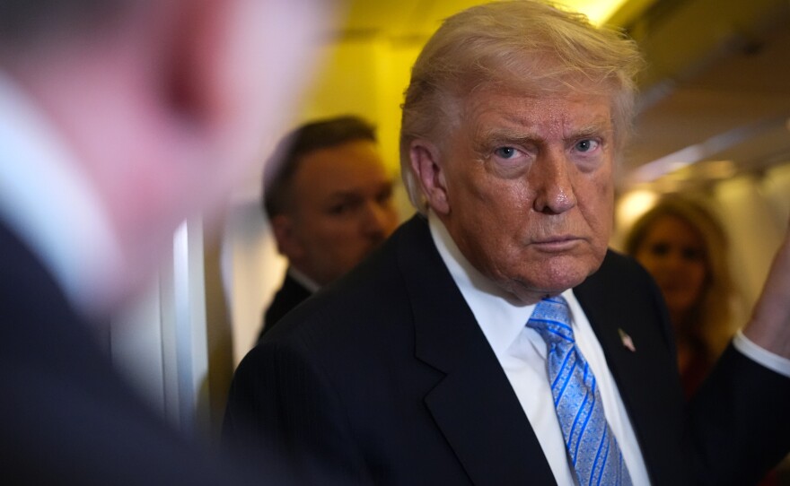 President Donald Trump speaks to reporters aboard Air Force One, Friday, May 15, 2026, as he returns from a trip to Beijing, China.