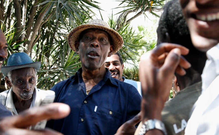 Leo Vigil Plutin, a pianist and baseball aficionado, debates the game with friends at La Esquina Caliente in Havana's Central Park.