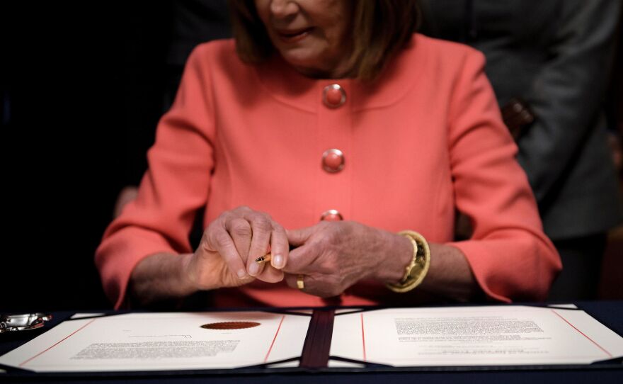 House Speaker Nancy Pelosi signs the articles of impeachment against President Trump at the Rayburn Room on Capitol Hill Jan. 15.