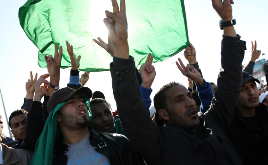 Men in Tripoli join in the part-protest, part-funeral for civilians said to have died during recent airstrikes in Libya. They gathered at a place along Libya's Mediterranean coast known as a cemetery for martyrs.