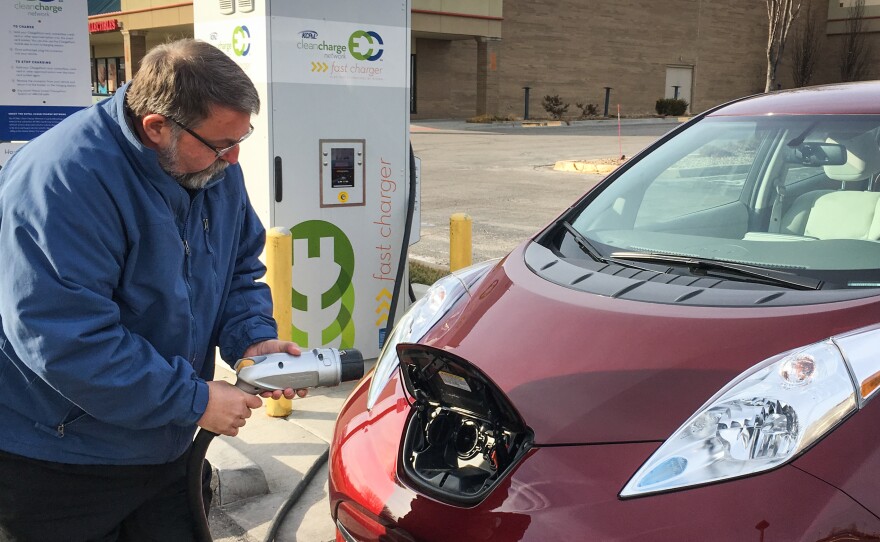 Larry Kinder, founder and CEO of LilyPad EV, gets ready to charge his Nissan Leaf at a fast-charging station at the Rosana Square Shopping Center in Overland Park, Kan.