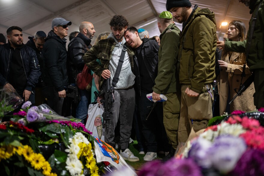 Family and friends of Israeli reservist Hadar Kapeluk, who was killed in combat in Gaza, mourn at his grave during his funeral at the Mount Herzl military cemetery in Jerusalem on Tuesday.