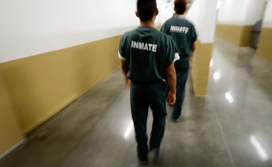 Inmates walk down a hallway at the Otay Mesa Detention Center in San Diego on Aug. 23, 2017.