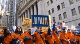Protesters march on Wall Street in front of the New York Stock Exchange, Tuesday, May 1, 2018. 