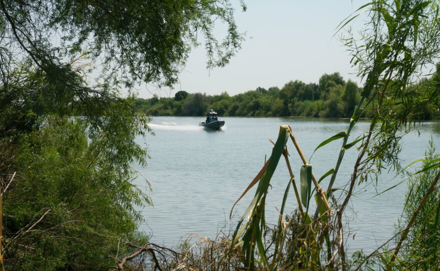 A U.S. Customs and Border Protection boat plies the waters of the Rio Grande near the edge of the National Butterfly Center.
