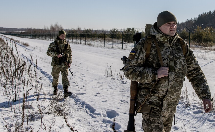 Members of the Ukrainian Border Guard patrol along the Ukrainian border fence at the Three Sisters border crossing between Ukraine, Russia and Belarus on Monday.