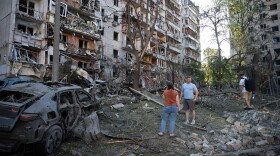 People look at a residential building damaged during the Russian missile attack in Kyiv, Ukraine, Thursday.