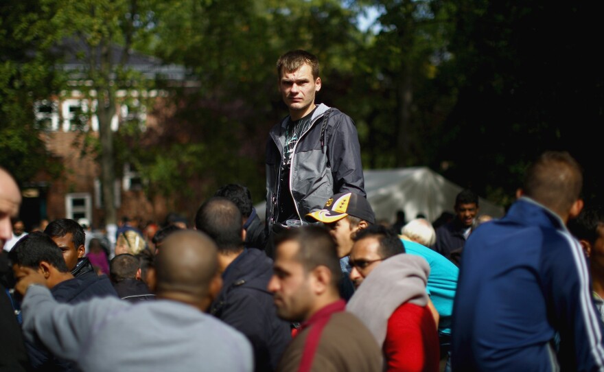 Refugees and migrants wait at the Regional Office for Health and Welfare in Berlin for food and a turn to start the paperwork to apply for asylum.