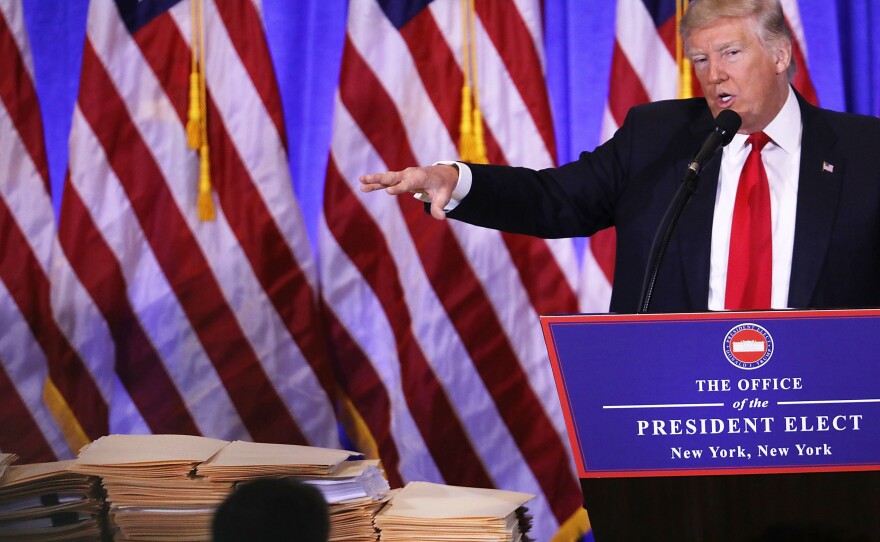 At a Jan. 11 news conference at Trump Tower on in New York City, President-elect Trump gestures at a stack of folders that he said contained documentation separating him from his businesses. That revocable trust was modified about a month later to let Trump withdraw from it at any time, ProPublica reports.