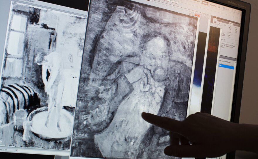 Scientists and art experts found a hidden painting beneath one of Picasso's first masterpieces, The Blue Room, thanks to advances in infrared technology. Here, associate conservator Patricia Favero of The Phillips Collection points to a detail in the image.