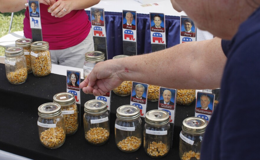 Iowa State Fair visitors place corn kernals in the jar of the candidate of their choice during an informal "corn poll" in 2011.
