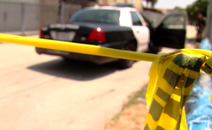 An undated file photo of a crime scene police tape and a San Diego Police Department cruiser in the background.
