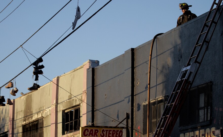 On Saturday, firefighters investigate the scene of the overnight fire at the Ghost Ship warehouse in the Fruitvale neighborhood of Oakland.