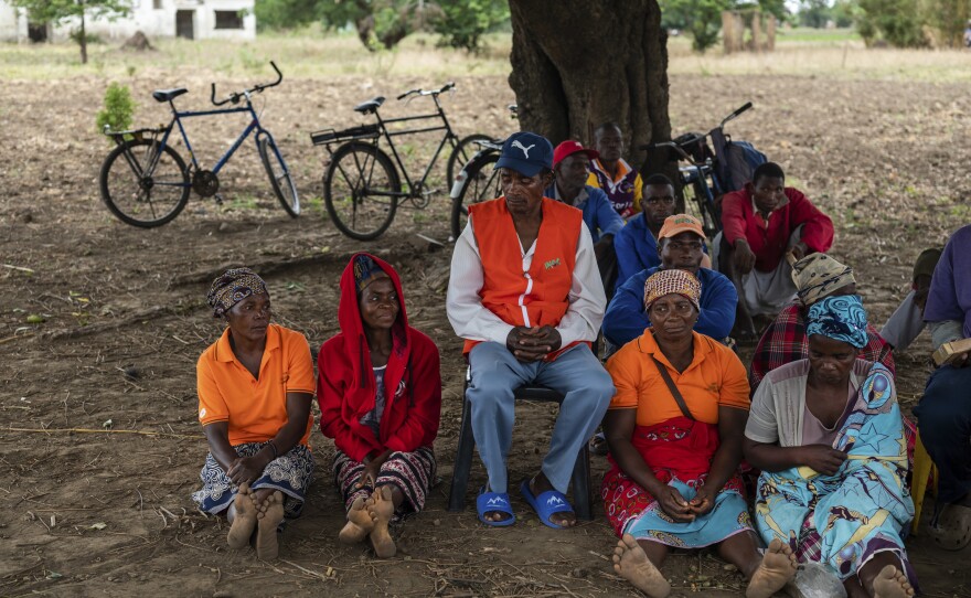 Farmers in the town of Mondiane meet to discuss sustainable farming practices in November. Members of the local disaster preparedness committee wear orange vests with the acronym for the national disaster preparedness agency.