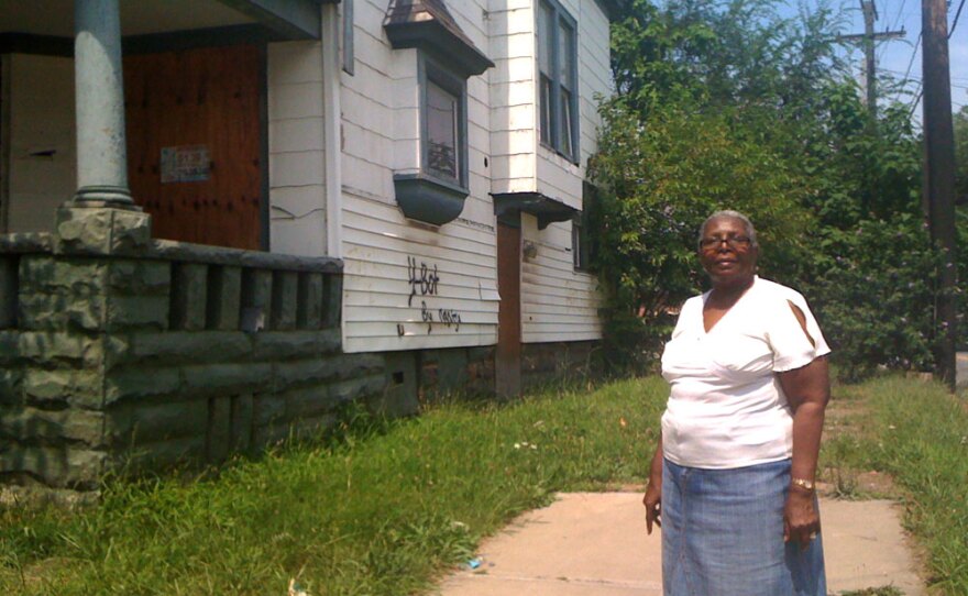 Edith Crum stands in front of a house, owned by out-of-state investors, that she wants torn down.
