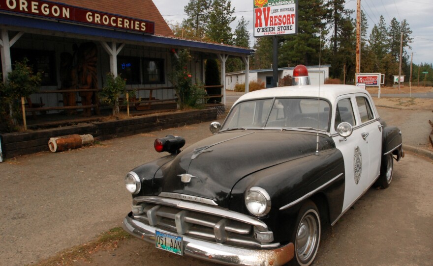 An old police car is permanently parked on the highway through O'Brien, Ore., where cuts to the sheriff's office have prompted some locals to mount crime patrols.