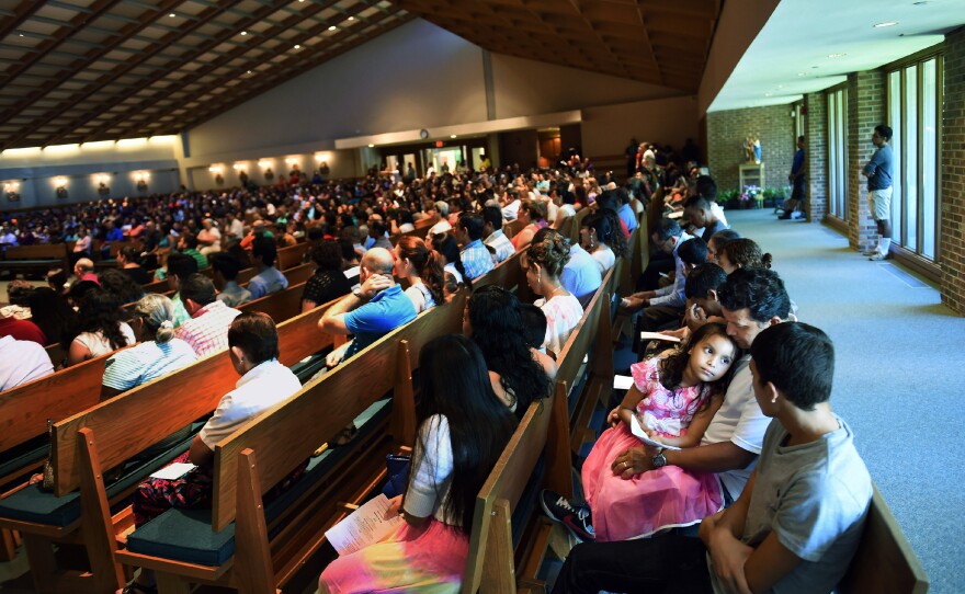 Rocio Cruz (facing camera), 7, sits with her father, Jose Carlos Cruz, during a Spanish Mass at Good Shepherd Catholic Church last month in Alexandria, Va. Hispanics account for 34 percent of American Catholics.