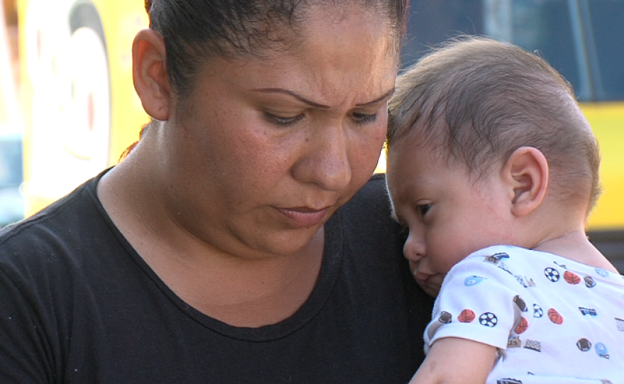 Leticia Barajas, a resident of Mineral de Santa Fe, stands near her home with her son, Aug. 27, 2015.