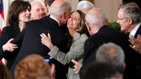 Vice President Joseph Biden hugs Speaker of the House Rep. Nancy Pelosi (D-CA) (C) as widow of the late Sen. Edward Kennedy (D-MA) Vicki Kennedy (L), and Senate Majority Leader Sen. Harry Reid (D-NV) (R) look on after he signed the Affordable Health Care for America Act during a ceremony with fellow Democrats in the East Room of the White House March 23, 2010 in Washington, DC.