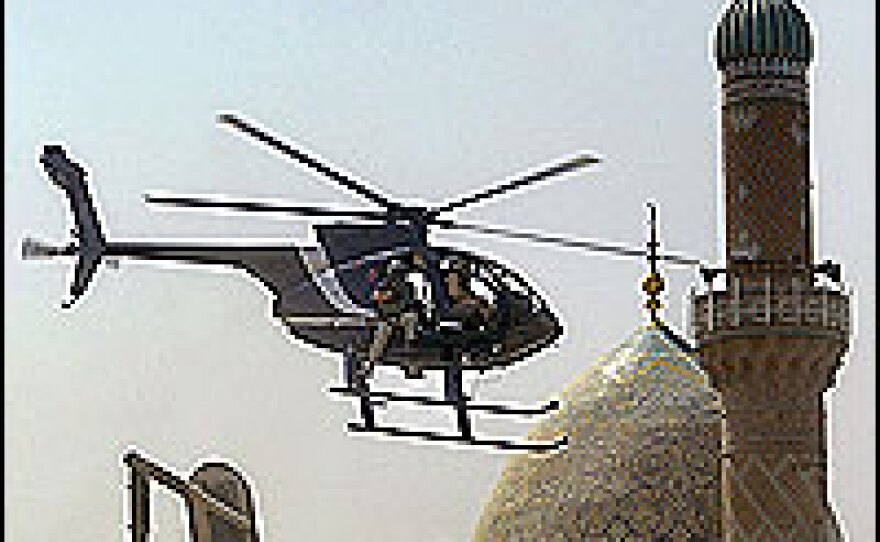 A Blackwater security firm helicopter flies low above a central Baghdad street.