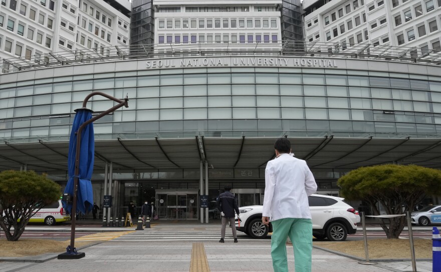 A medical worker walks to enter Seoul National University Hospital in Seoul, South Korea, Thursday, Feb. 29, 2024.