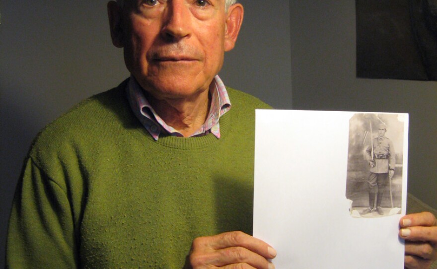 Fausto Canales, 75, holds a photo of his father, Valerico, pictured as a 21-year-old conscript. Fausto Canales has been fighting to get his father's remains removed from the Holy Cross of the Valley of the Fallen.