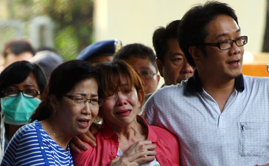 Relatives of Juanita Limantara, one of the victims of the AirAsia Flight QZ8501 crash, weep during the handover of her body to the family at a police hospital in Surabaya today.