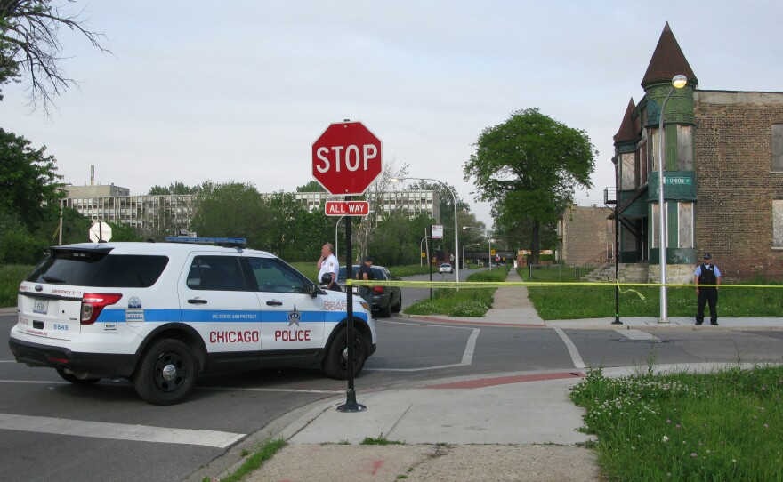 Police cordon off the area around a shooting in Chicago Wednesday. The violence broke out down the street from where an interview about guns in the city was being conducted.