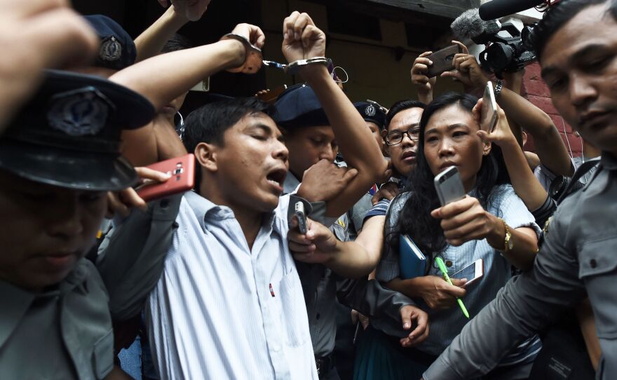 After being sentenced on Monday to seven years, Kyaw Soe Oo is escorted out of the courthouse by police. He and fellow Reuters journalist Wa Lone were accused of breaking a law on state secrets.