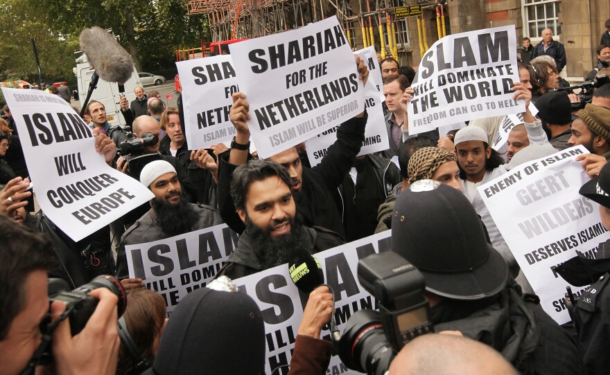 Protestors hold placards outside a press conference being held by right-wing Dutch MP Geert Wilders on Oct. 16, 2009, in London. About 20 protestors gathered outside the building where he held a press conference.