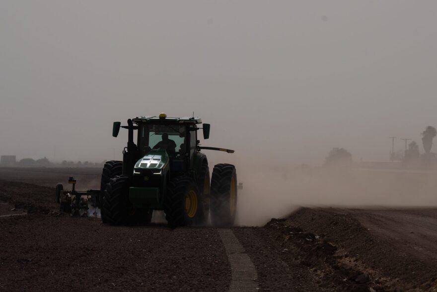 A tractor cuts through the dust in a field near Brawley, Calif. on Aug. 6, 2024. 