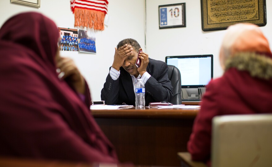 Shekhey makes phone calls to help Alemnesh Tekaliny (right) get answers to her tax questions. A steady stream of people regularly seek help at the center's small office.