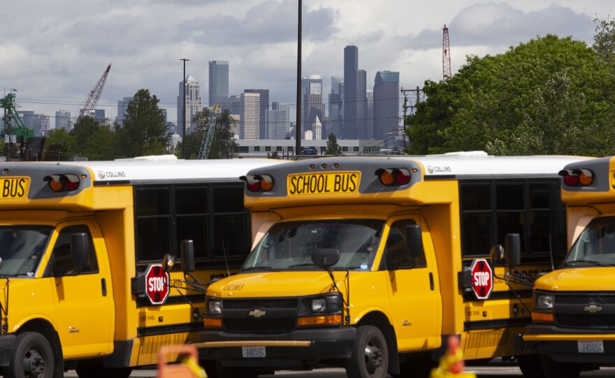 School buses sit idle in a Seattle bus yard. On July 2, Seattle Public Schools announced it is planning to resume some in-person learning in the new school year.