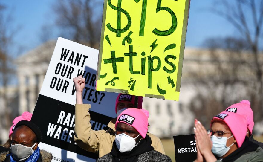 An activist holds a placard demanding a $15 per hour minimum wage and tips for restaurant workers during a rally at the House Triangle of the US Capitol in Washington, D.C. on Feb. 8.