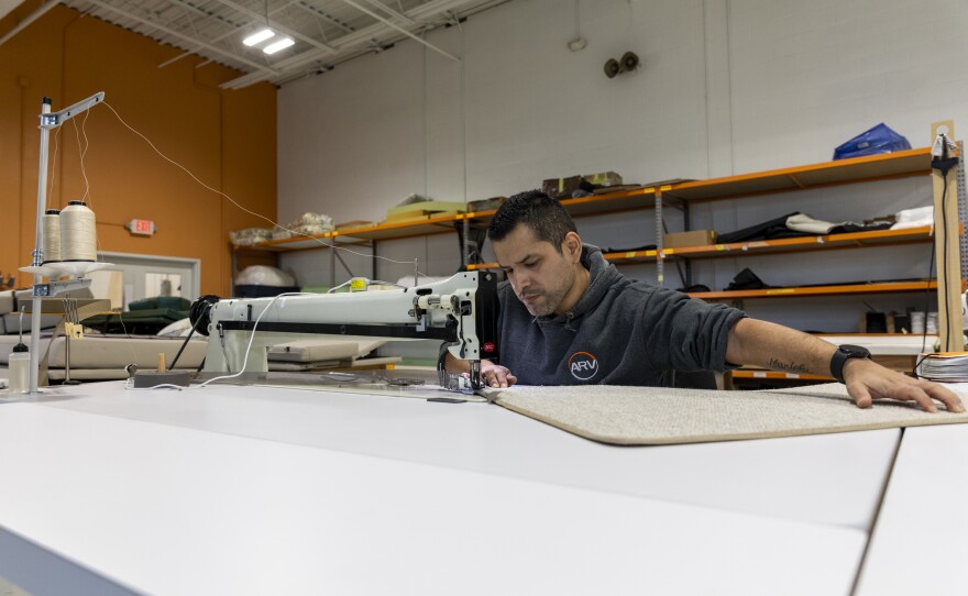 Master upholsterer Alex LLacsahuanga works on an industrial sewing machine that Advanced RV purchased as part of a push to find efficiencies. The sewing machine helps cut the time it takes to bind carpets.