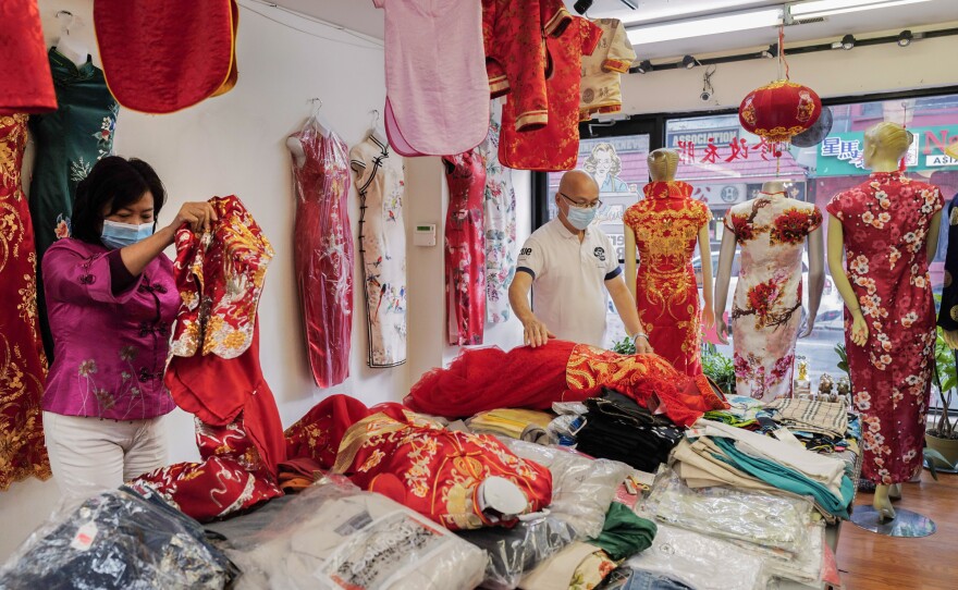 In 2000, when Lai saw better housing options in Philadelphia, she decided to move there, founding Dia Boutique, a shop in Chinatown that sells cheongsams and provides alteration services. Here, the couple arrange the cheongsams in the shop.