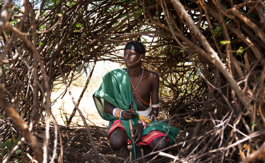 Ltesekwa sits in the shelter where he sleeps at this mountain campsite.