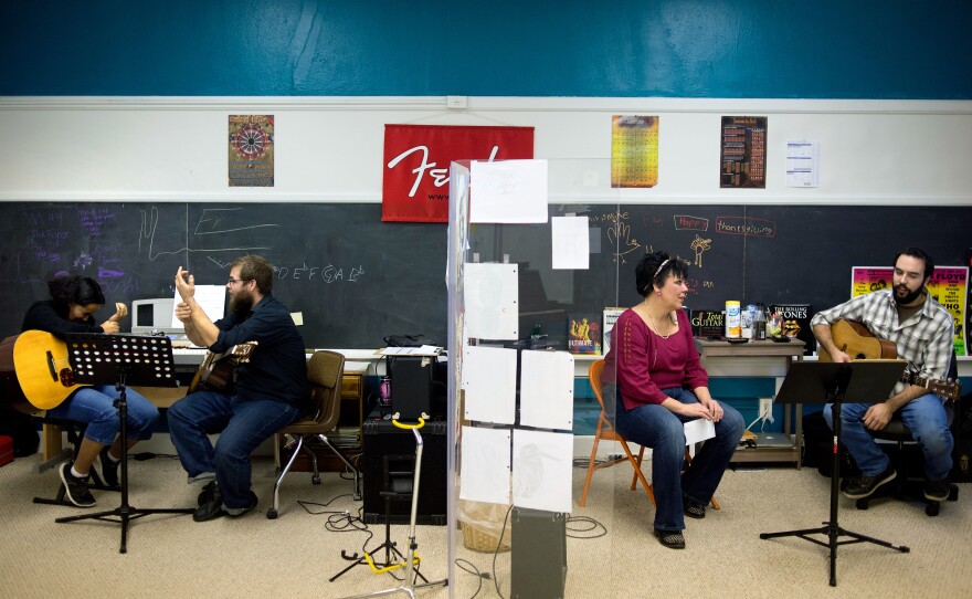 (From left) Tanzania Cantrell, 13, and her guitar teacher Ryan Fitzgerald talk about wrist cramps while Katrina Vowell, talks to guitar instructor Mike Tesch before one of his lessons begins.