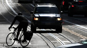 A bicyclist rides down the street during this year's Bike to Work Day in San Francisco. Events such as this promote biking as a viable form of commuting, but tensions between cyclists and drivers persist.