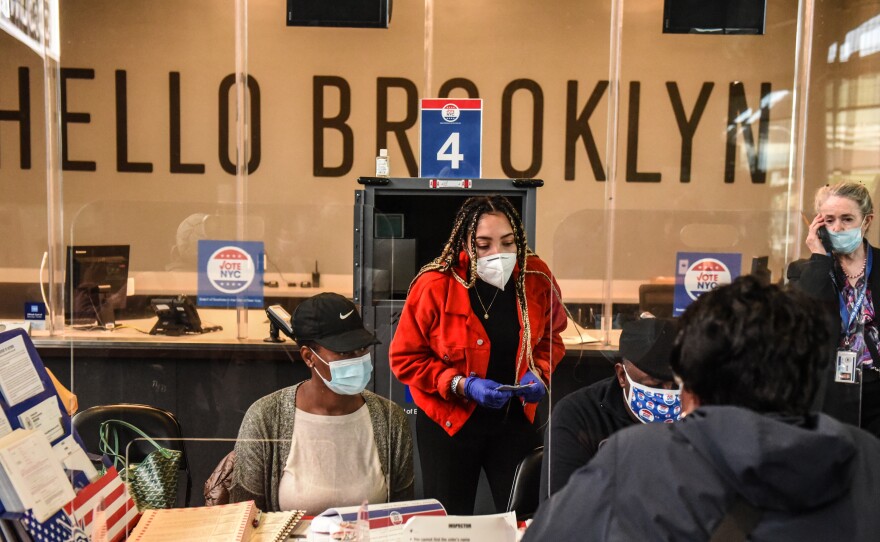 Poll workers check in a voter at the Barclays Center in New York City on Oct. 24.
