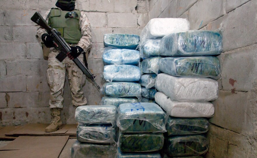 A Mexican soldier stands guard next to marijuana packages in Tijuana following the discovery of a tunnel under the U.S.-Mexico border in 2010.