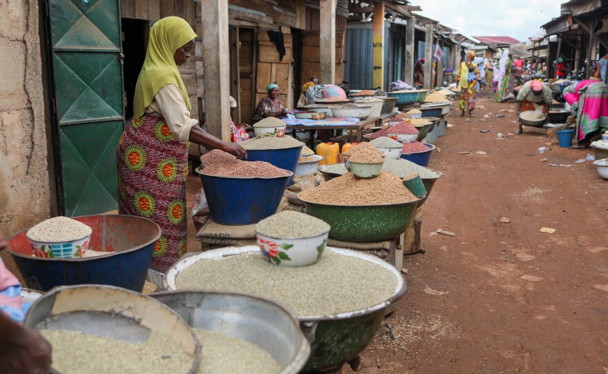 A vendor sorts grains at a market in Ghana. Fonio, a drought-resilient grain native to West Africa, could bolster the regional food supply if there are advances in its harvesting and processing.