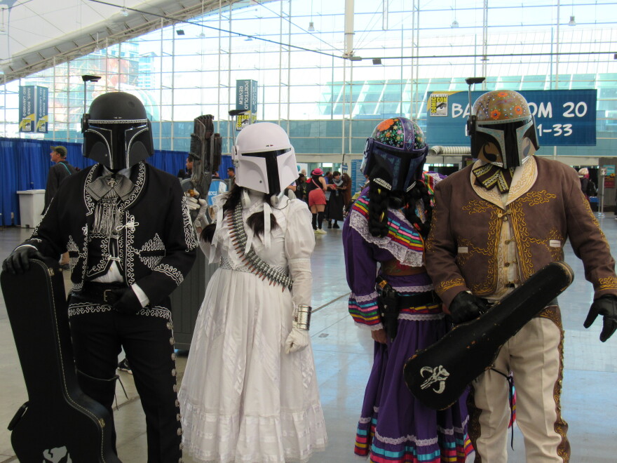 A group of Comic-Con attendees dressed as mariachi-inspired storm troopers stand under a Comic-Con banner on July 26, 2025.
