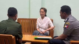 In this undated photo provided on April 30, 2026, by the Myanmar Military True News Information Team, the country's former leader Aung San Suu Kyi, center, talks with officials in an undisclosed location in Myanmar.