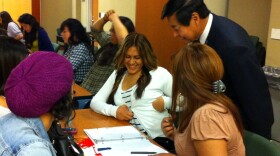 Craig Ogino, Chula Vista Police Department crime lab director, stops to check the work of Chula Vista High Tech High School student Jennifer Cabrera, 17, and her classmates during the How to Use Math to Solve Crime program at the Chula Vista Police Department crime lab, April 5, 2011.