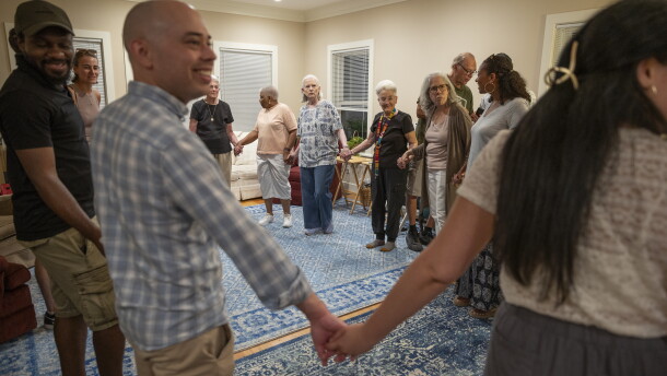 Former residents, current residents and friends of Anne Montgomery House begin a traditional Greek dance at the farewell celebration in Washington, D.C. on July 31, 2026. The community house, run by Society of the Sacred Heart, is closing after a decade.