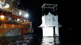 The 100-ton containment vessel is lowered into the Gulf of Mexico late Thursday at the site of the Deepwater Horizon rig collapse.